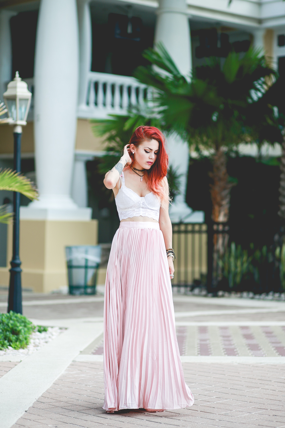 Le Happy wearing pastel pleated skirt and lace bustier in summer
