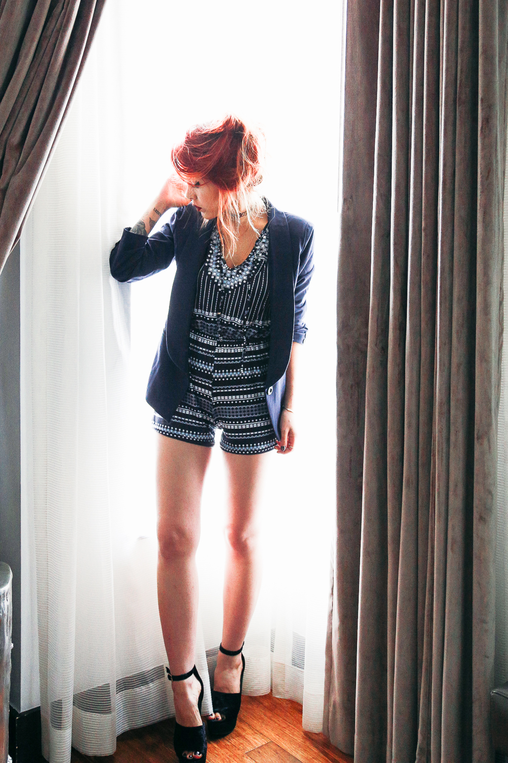 Le Happy wearing blue blazer and dressy printed romper