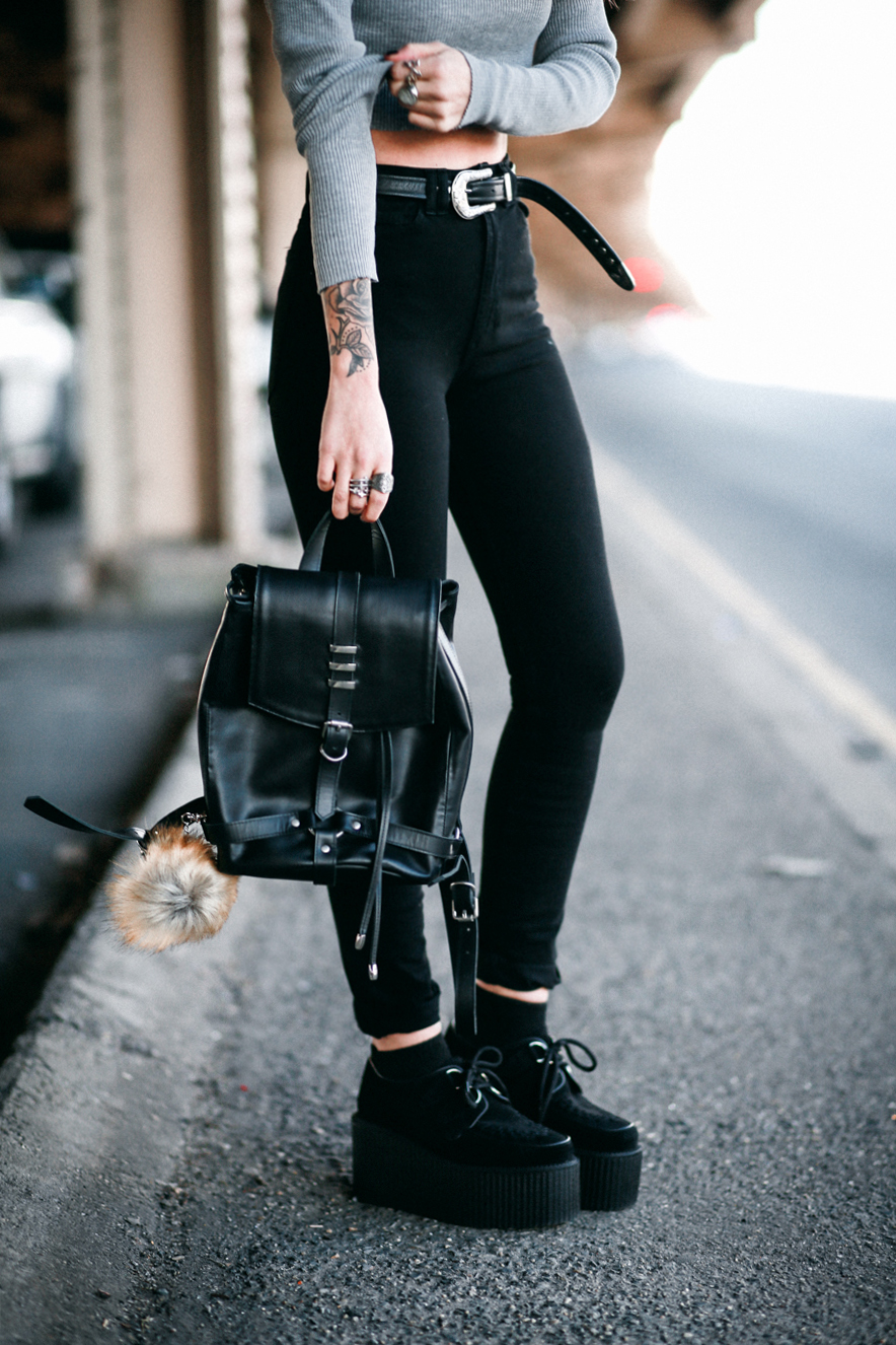 Lua of Le Happy wearing high waisted pants and black leather backpack