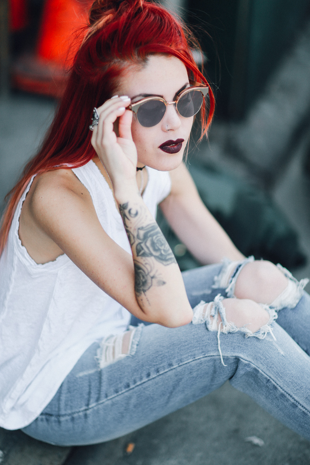 Le Happy wearing ripped jeans and Le Specs Luxe Cleopatra sunglasses