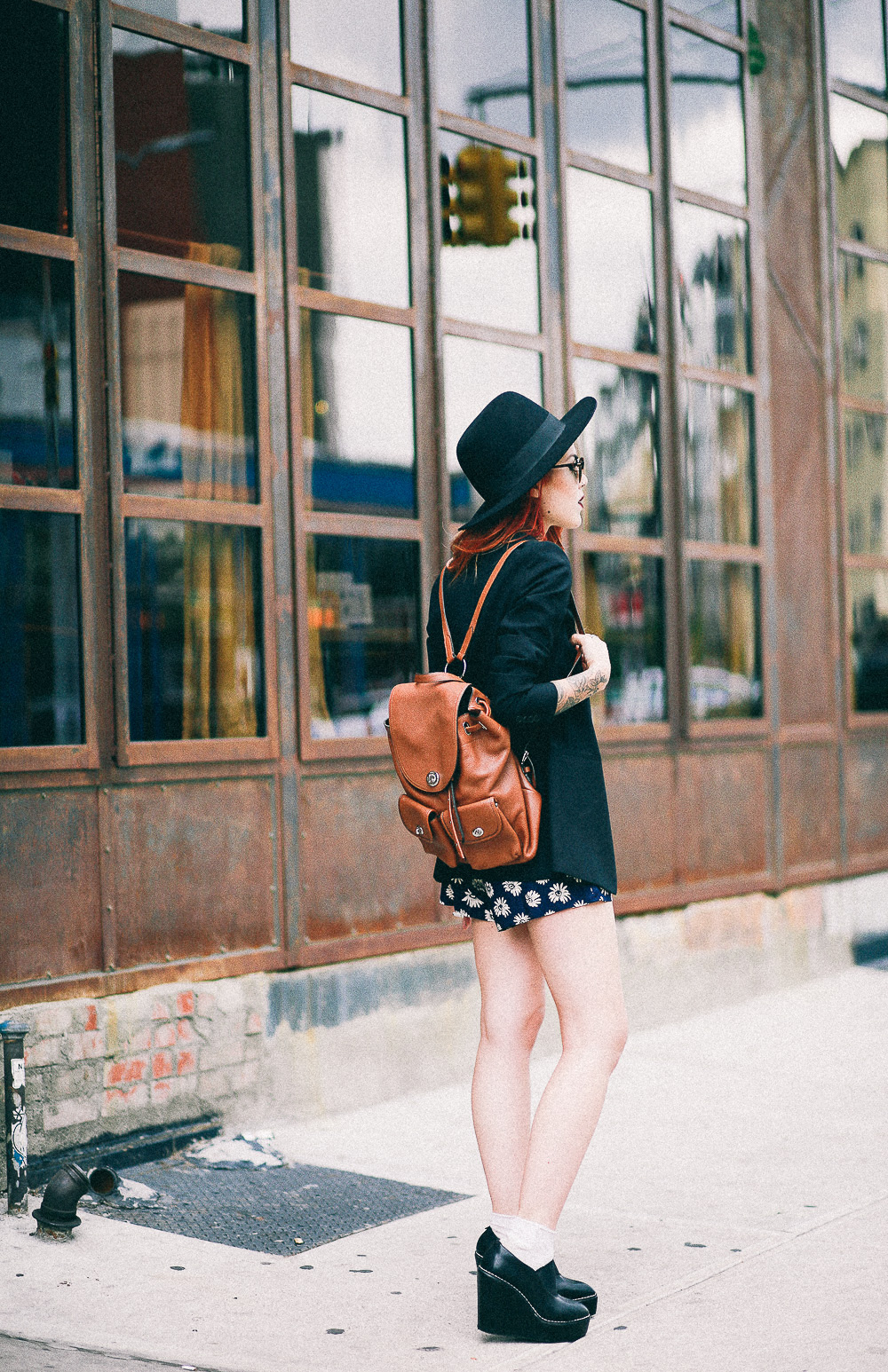 Le Happy wearing Coach camel backpack and Theory black blazer