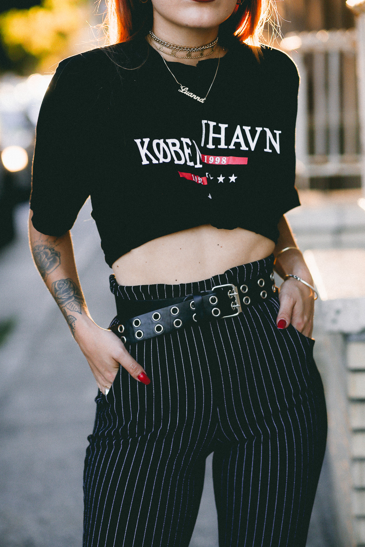 Pinstripe pants paired with double hook belt and a graphic black and red t-shirt